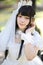 Beautiful young woman with white lolita dress with european garden Japanese fashion