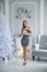 Beautiful young woman in white studio with wonderful Christmas decorations and luxury interior!