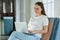 Beautiful young woman working on a laptop in a home interior. Freelancer A modern business woman uses a laptop for