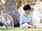 Beautiful young woman writing in her diary outdoors