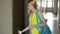 Beautiful young woman in yellow dress closing the door of her apartment with keys and leaving