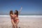 Beautiful young women in bikini dancing at beach in the sunshine