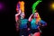 Beautiful young women in carnival and masquerade costume in colorful neon lights on black background