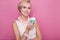 Beautiful young women holding small cake with colorful candle. Birthday, holiday