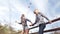 Beautiful young women jumping across fence running