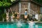 beautiful young women in swimwear jumping in swimming pool at tropical