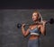 Beautifull fitness woman in gray sportswear doing exercise with a barbell in the fitness center.