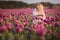 Beautifull happy woman with long hair in white dress lonely walking in the Lilac Poppy Flowers field