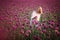 Beautifull happy woman with long hair in white dress lonely walking in the Lilac Poppy Flowers field