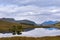 Beautifull lake with reflections of the trees and surrounding mountains in the Scottish Highlands, in Scontland, United Kingdom