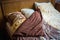 Beautifull linens, pillows and blankets on brown wooden bed