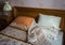 Beautifull linens, pillows and blankets on brown wooden bed and
