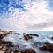 Beautifull Sunset clouds over sea stones near to beach