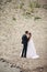 Beautifull wedding couple kissing and embracing near the shore of a mountain river with stones