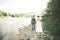 Beautifull wedding couple kissing and embracing near the shore of a mountain river with stones