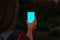 Beautifull young girls hand holding smartphone with blank screen. Blue screen