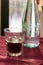 A beautifully backlit glass of red soft drink on a restaurant table