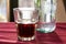 A beautifully backlit glass of red soft drink on a restaurant table