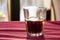 A beautifully backlit glass of red soft drink on a restaurant table