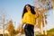 Beautifully bent body curly brunette poses in autumn park