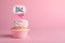 Beautifully decorated baby shower cupcake with cream and girl topper on pink background. Space for text