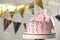 Beautifully decorated birthday cake on stand against blurred festive lights. Space for text