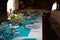 Beautifully decorated white blue festive table with plates and glasses and bouquet of flowers in restaurant