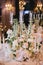 A beautifully designed banquet table with floral composition of buttercups and white roses, old porcelain plates