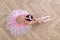 Beautifully dressed little ballerina on floor in studio, top view