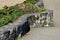 Beautifully folded retaining wall with a granite attic with small joints. brown beige yellow irregular gneiss stone holding a slop