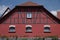 Beautifully renovated cowshed with red half-timbered facade and red roof under a blue sky