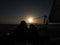 Beautifully romantic sunset on a boat in the open sea where you can see the sun setting behind the mountain, beautiful background