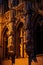 Beautifully sculpted columns and statues in front of arched windows in a gothic cathedral
