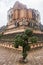 Beautifully trimmed tree in Wat Chedi Luang temple complex in Chiang Mai, with the huge stupa or chedi in the background