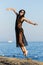 Beautifyl woman jumping high near an ocean