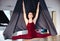 Beautiul young woman doing aerial yoga on black hammock