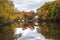 Beautuful scenry with boathouses along a river with forested banks