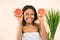 Beauty afro woman with orange citrus grapefruit with healthy skin body, isolated over white background. Attractive fresh