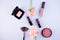 Beauty background makeup cosmetic product,with green leaf and pink rose blossom on purple spring background. woman mother day