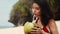 Beauty, baunty, travel, fashion concept.Beautiful pretty asian woman in hat and red dress drinking coconut on tropical