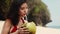 Beauty, baunty, travel, fashion concept.Beautiful pretty asian woman in hat and red dress drinking coconut on tropical