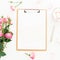 Beauty blog composition with marshmallow, envelope, pink roses bouquet and clipboard on white background. Top view. Flat lay.