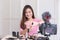 Beauty blogger of Asian female tutorial makeup cosmetics live broadcasts video streaming. Vlogger are smiling while reviewing