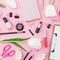 Beauty blogger composition with clipboard, flowers, cosmetics and accessory on pink background. Top view. Flat lay.