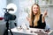 Beauty blogger woman filming daily make-up routine tutorial near camera on tripod. Influencer blonde girl live streaming