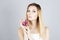 Beauty blonde with pink flower in hand. Woman with permanent make up. Beauty face