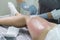 Beauty and Bodycare Concepts. Close-up of Beautician During Wax Depilation Procedure of Woman Legs By Wax Strips on Female Legs in