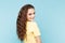 Beauty casual fasion portrait. Curly hair nice woman posing isolated over the blue background.