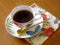 Beauty coffeecup standing on wooden table with dark tasty coffee