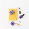 Beauty composition with yellow notebook, blue anemones and nail polish on white background